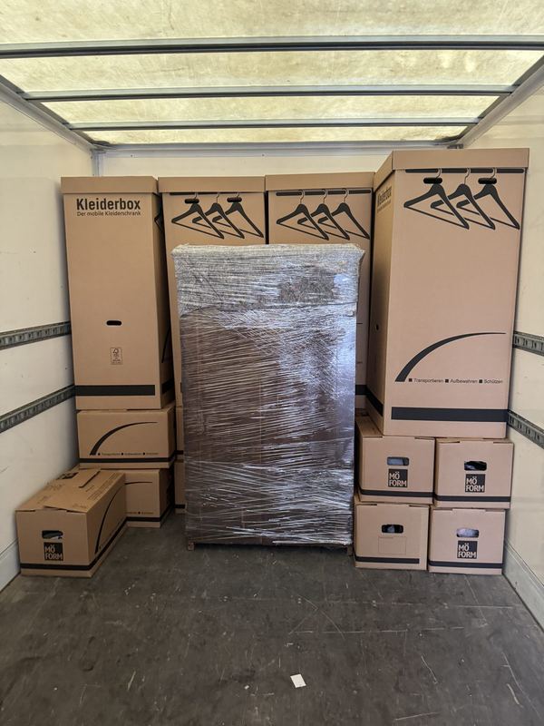 Ein Laderaum mit einer Reihe Kleiderboxen, mittig steht ein folierter Schrank
