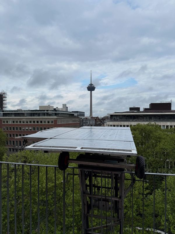 Möbelliftplattform auf Höhe eines oberen Stockwerks, im Hintergrund ein Fernsehturm