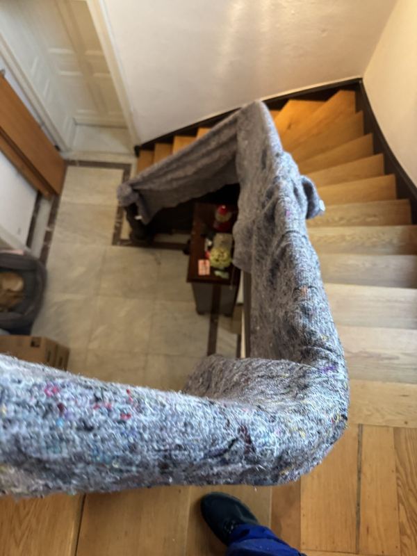 Ein Treppengeländer ist von oben bis unten mit einer Umzugsdecke umwickelt